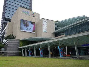 Auronova technician installing LED display panel modules on large outdoor screen in Singapore